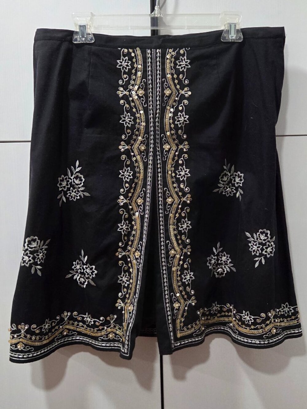black A-line knee-length skirt featuring elaborate boho-style floral embroidery,